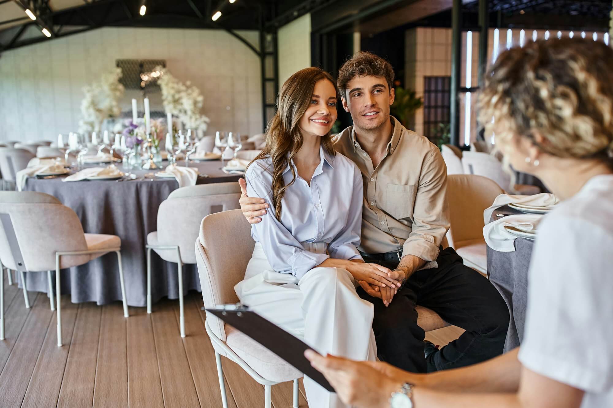 banquet-organizer-with-clipboard-talking-to-couple-in-love-in-event-hall-with-wedding-decor.jpg banquet-organizer-with-clipboard-talking-to-couple-in-love-in-event-hall-with-wedding-decor.jpg